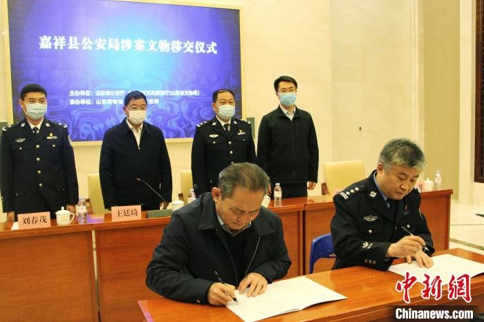 山東博物館館長鄭同修和嘉祥縣人民政府副縣長、公安局局長趙健簽署移交協(xié)議。　趙曉 攝