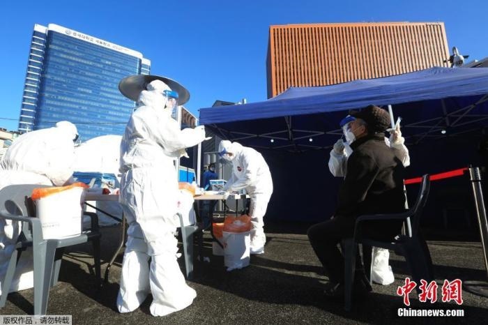 資料圖：韓國(guó)首爾，醫(yī)務(wù)人員對(duì)市民進(jìn)行新冠病毒檢測(cè)。