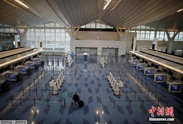 資料圖：日本東京，東京國際機(jī)場，一名乘客在國際航班航站樓的登機(jī)區(qū)。