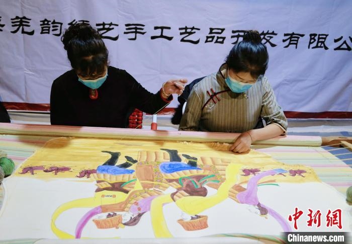 圖為皮繡藝人在市集上“秀”指尖技藝?！●R銘言 攝