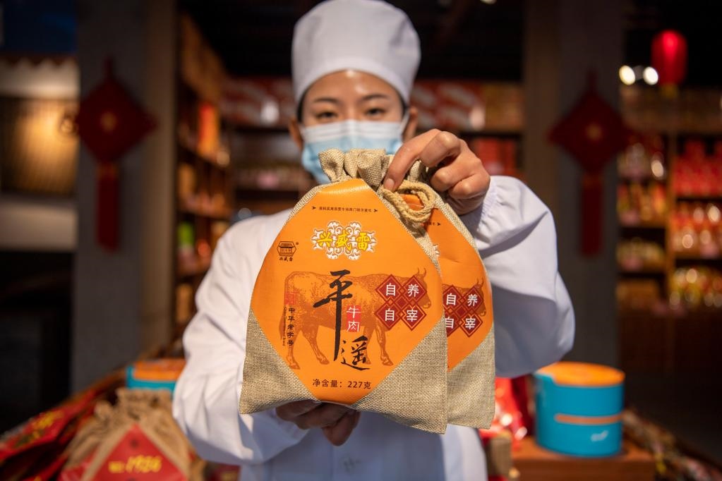 1月27日，在平遙古城南大街的一家平遙牛肉店內(nèi)，工作人員展示一款牛肉產(chǎn)品。新華社記者 楊晨光 攝