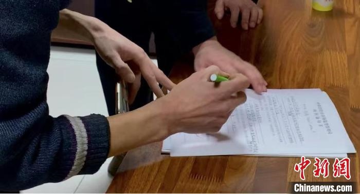 圖為現(xiàn)場下達詢問通知書。　李婷婷 攝