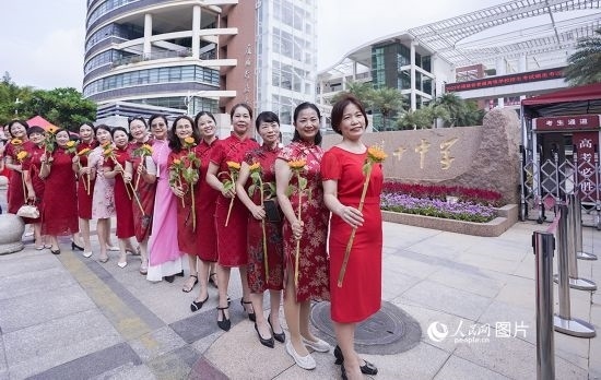6月7日一早，廈門(mén)雙十中學(xué)考生家長(zhǎng)們身穿旗袍，手拿向日葵在考場(chǎng)外為孩子加油打氣，寓意“旗開(kāi)得勝，一舉奪魁”。人民網(wǎng)記者 陳博攝
