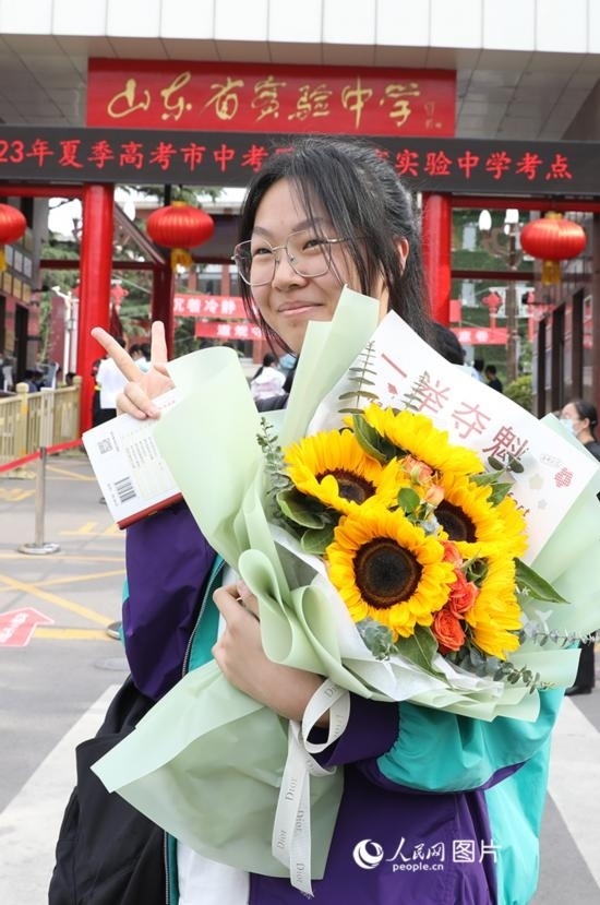 6月7日高考首日，山東67萬(wàn)考生走進(jìn)考場(chǎng)，拼搏逐夢(mèng)。在山東省實(shí)驗(yàn)中學(xué)考點(diǎn)，考生進(jìn)考場(chǎng)前手捧向日葵花拍照留念，寓意“一舉奪魁”。人民網(wǎng)記者 劉祺攝