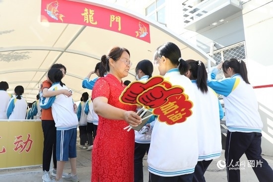 6月7日一早，雄安新區(qū)安新中學(xué)老師在給同學(xué)們加油鼓勁兒。人民網(wǎng) 李兆民攝