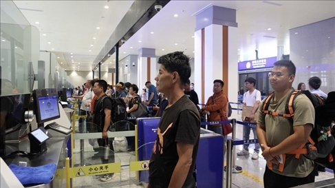 6月13日，乘坐中老鐵路國際旅客列車的旅客在磨憨邊檢大廳排隊候檢。李揚 攝