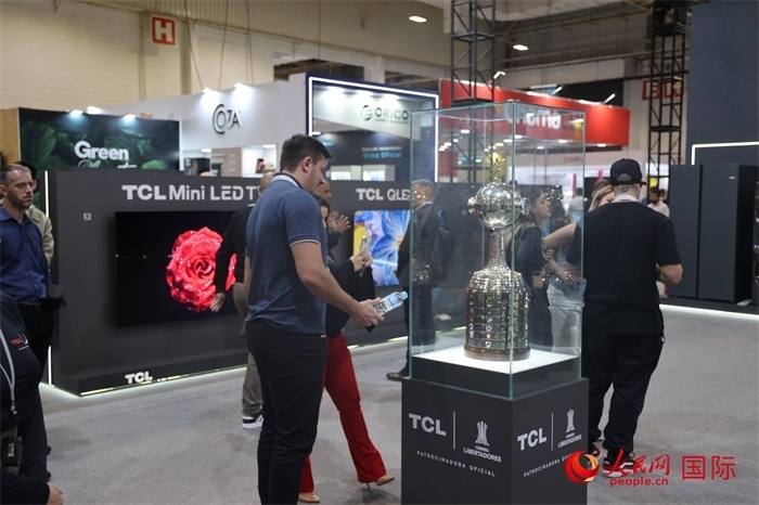 參觀者在TCL展臺前觀看南美解放者杯獎杯，據(jù)介紹，TCL是南美解放者杯（2023—2026賽季）全球官方合作伙伴。（人民網(wǎng)記者 時元皓攝）