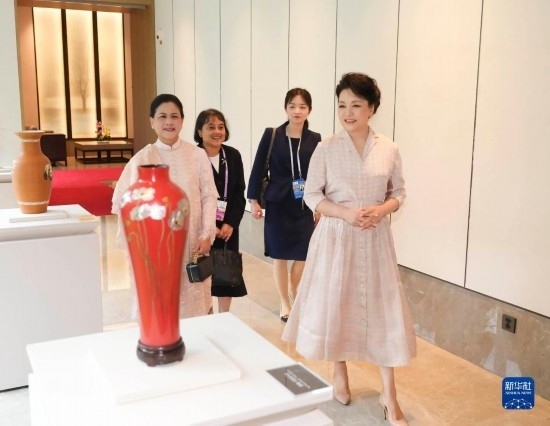 7月27日下午，國家主席習近平夫人彭麗媛在四川成都會見陪同印度尼西亞總統(tǒng)佐科來華出席第31屆世界大學生夏季運動會開幕式并訪華的總統(tǒng)夫人伊莉亞娜。這是彭麗媛和伊莉亞娜欣賞成都特色非遺工藝品。新華社記者 丁林 攝