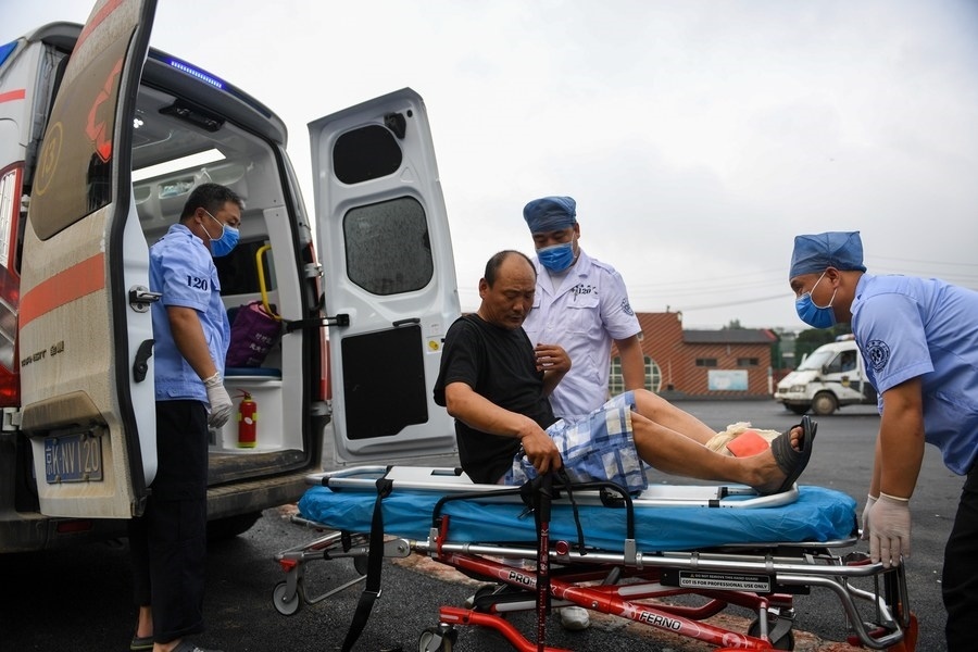 8月1日，在北京市門頭溝區(qū)妙峰山鎮(zhèn)妙峰山民族學(xué)校臨時(shí)安置點(diǎn)，北京急救中心工作人員在轉(zhuǎn)運(yùn)一名受傷村民。新華社記者 鞠煥宗 攝