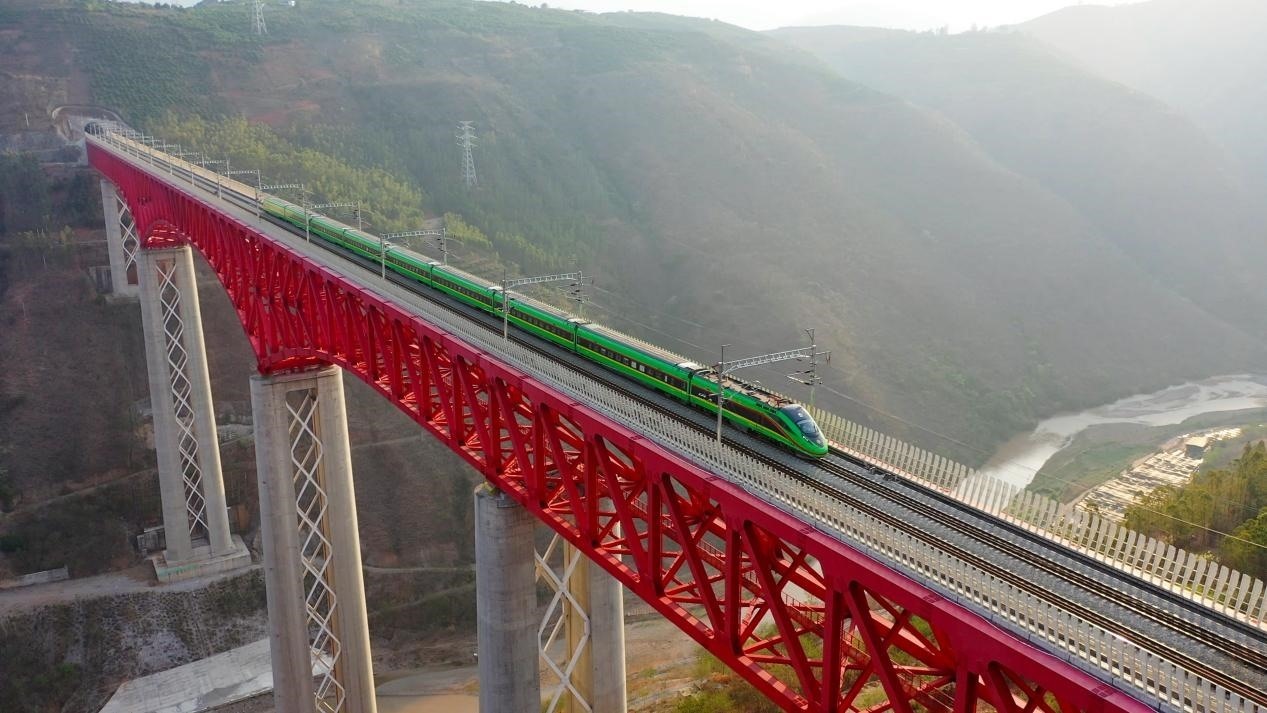 中老鐵路國(guó)際旅客列車在云南省境內(nèi)的元江特大橋上飛馳。姚巍攝