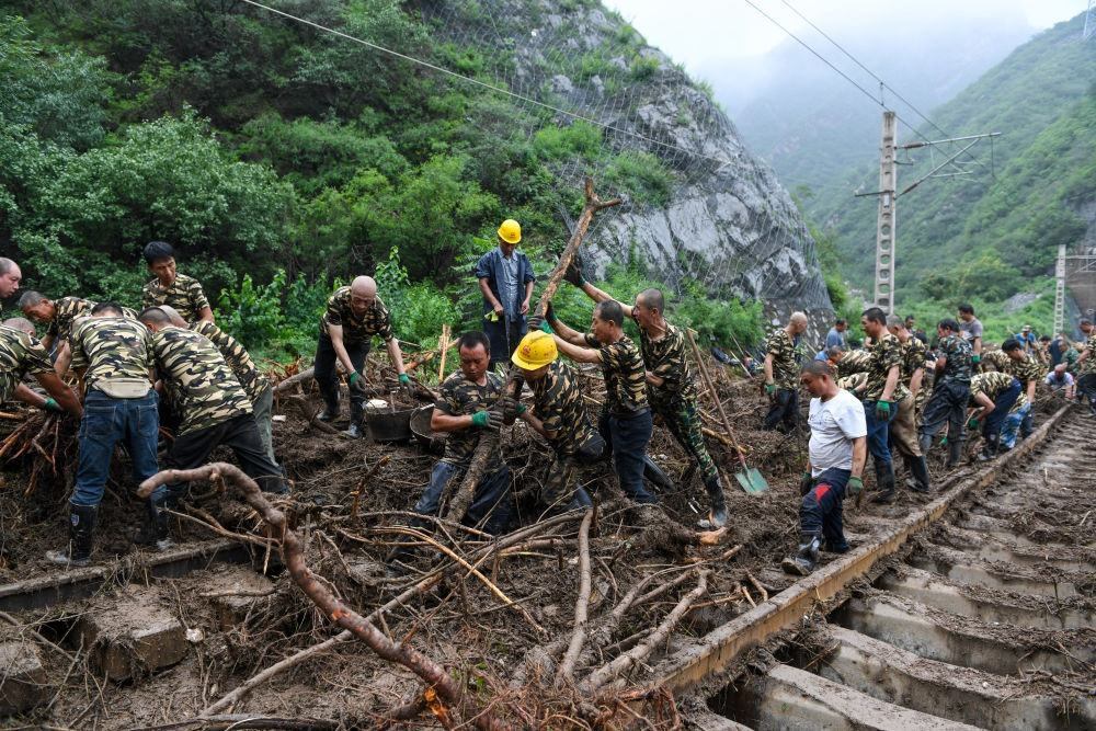 8月1日，在北京市門頭溝區(qū)水峪嘴村附近一段被阻斷的鐵路線上，中鐵六局工作人員在清理軌道上的雜物，全力恢復交通。新華社記者 鞠煥宗 攝