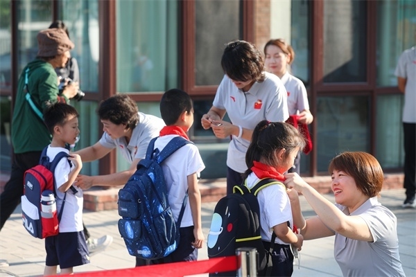 8月30日，雄安史家胡同小學(xué)學(xué)生體驗(yàn)學(xué)校生活。老師為學(xué)生佩戴校徽。