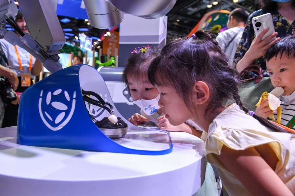 9月3日，幾名小朋友在國家會議中心觀看單孔腔鏡手術(shù)機器人展示。新華社記者 鞠煥宗 攝