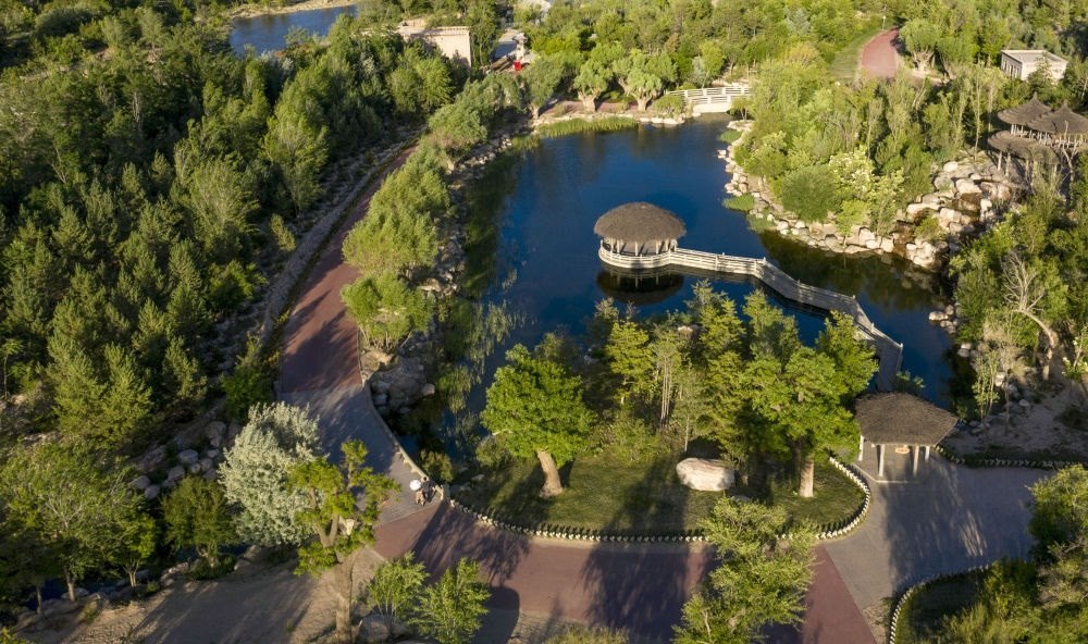 坐落在寧夏銀川市賀蘭山腳下的賀蘭山運動休閑公園（2021年5月27日攝，無人機照片）。這里曾是一片砂石采礦塌陷區(qū)，當(dāng)?shù)赝ㄟ^植被景觀再造、水系建設(shè)、現(xiàn)代管網(wǎng)鋪建等手段，重新利用廢石、廢坑及各類廢棄建筑材料，把這里變成一座免費開放的主題公園。新華社記者 馮開華 攝