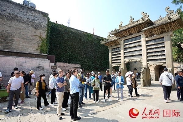 選手們認(rèn)真聆聽導(dǎo)游講解。人民網(wǎng) 盧鵬宇攝