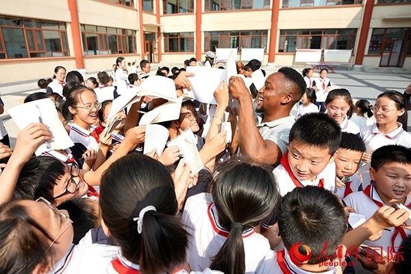 孩子們和選手互動(dòng)簽名。人民網(wǎng) 盧鵬宇攝