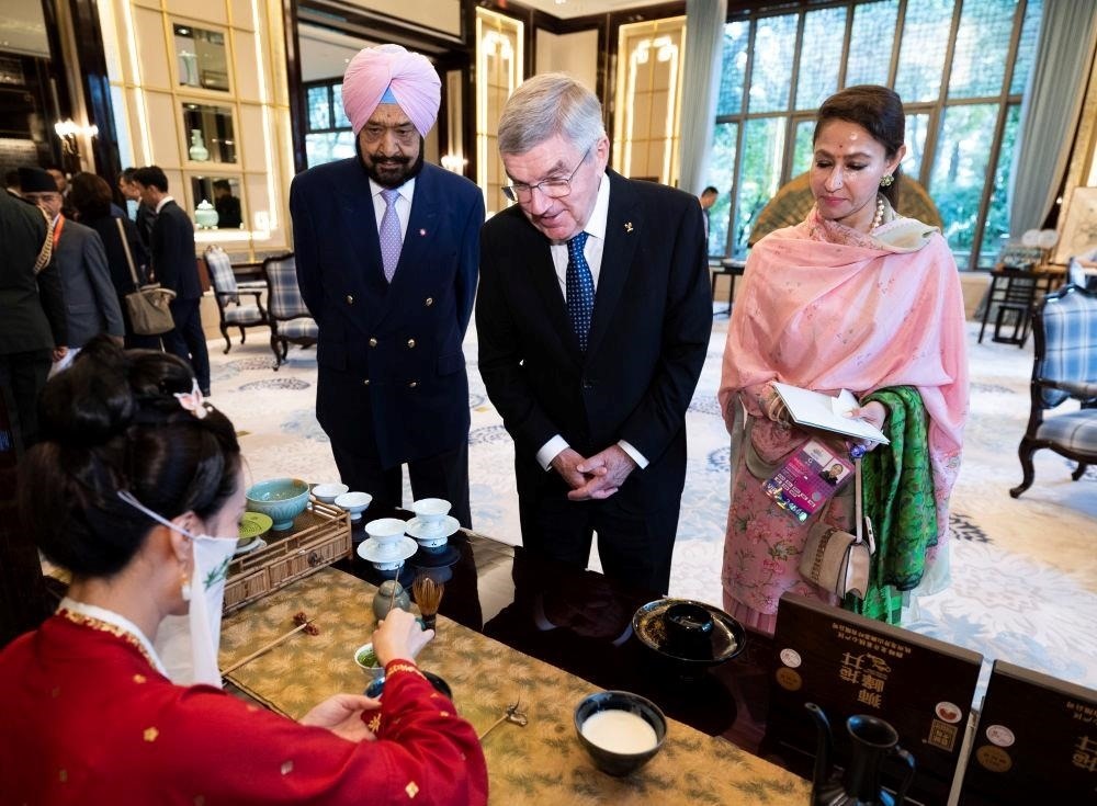 △歡迎宴會前，亞奧理事會代理主席辛格和夫人維尼塔、國際奧委會主席巴赫欣賞非遺展示。