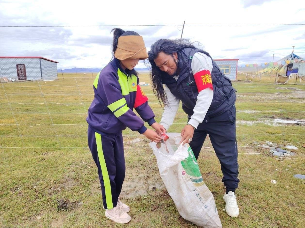 玉樹州稱多縣珍秦鎮(zhèn)河湖志愿者才培和他女兒更求拉毛在清掃垃圾。受訪者供圖