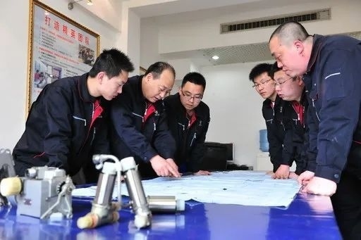 △李志強(qiáng)（左二）與班組成員在研究工作。