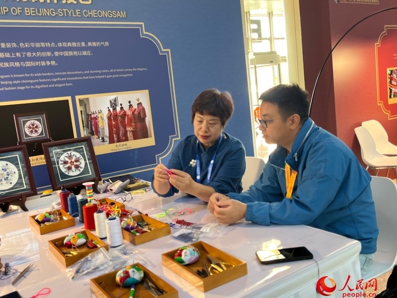 記者在新聞中心非遺傳承人展區(qū)進行體驗。人民網(wǎng)記者 杜燕飛攝