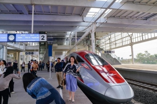  10月17日，在印度尼西亞萬隆德卡魯爾站，乘客在站臺上和雅萬高鐵高速動車組列車合影。新華社記者 徐欽 攝