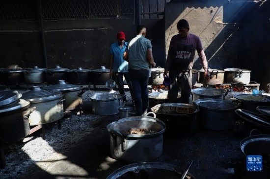 11月3日，在加沙地帶南部城市拉法，人們?cè)诿簹庵袛嗪笥貌窕鹱鲲?。新華社發(fā)（里澤克·阿卜杜勒賈瓦德攝）