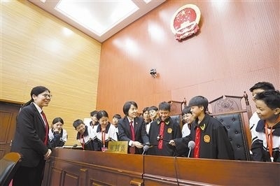圖③：同學們穿法袍、敲法槌，爭做“小法官”。