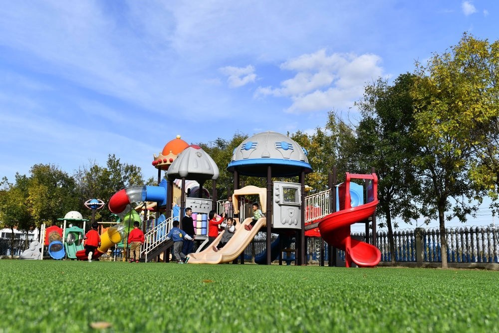 在山東省東營(yíng)市墾利區(qū)楊廟社區(qū)幼兒園，孩子們?cè)诶蠋煹膸ьI(lǐng)下進(jìn)行戶外活動(dòng)（2021年10月19日攝）。新華社記者 郭緒雷 攝