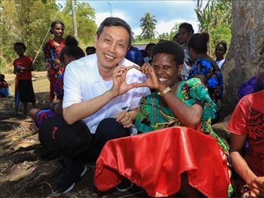 2023年12月18日，中國駐瓦努阿圖大使李名剛和前來觀看瓦努阿圖公路項目二期馬勒庫拉段移交儀式的當地居民合影。人民網 賀吉攝