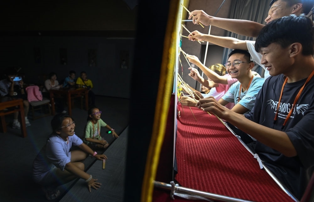 2023年8月8日，進行暑期研學(xué)的學(xué)生在位于陜西省西安市的中國秦腔藝術(shù)博物館體驗皮影戲演出。新華社記者 鄒競一 攝