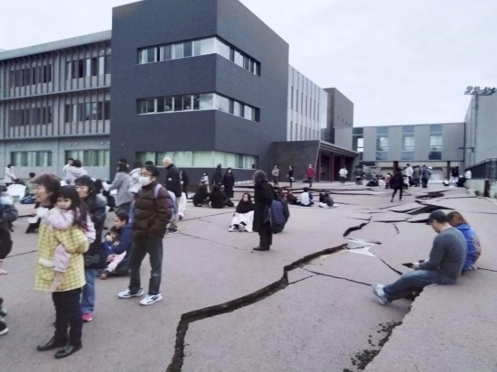  1月1日，在日本石川縣輪島市，人們站在被地震破壞的地面上。新華社/共同社