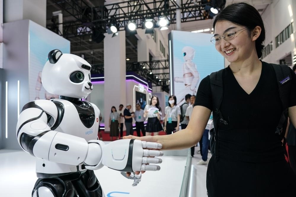 2023年8月16日，一名女士在北京舉辦的2023世界機(jī)器人大會(huì)現(xiàn)場(chǎng)與智能機(jī)器人握手。新華社記者彭子洋攝