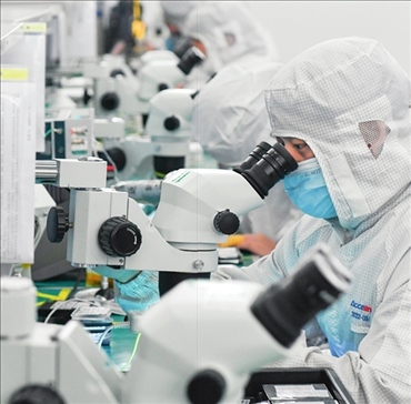 在位于武漢中國光谷的光電器件研發(fā)制造商——武漢光迅科技股份有限公司生產(chǎn)車間內(nèi)，技術(shù)人員在光模塊生產(chǎn)線作業(yè)（2023年4月11日攝）。程敏攝/本刊
