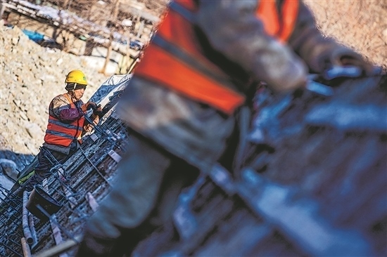 1月3日，房山區(qū)，工人正在雙泉河修筑堤壩。