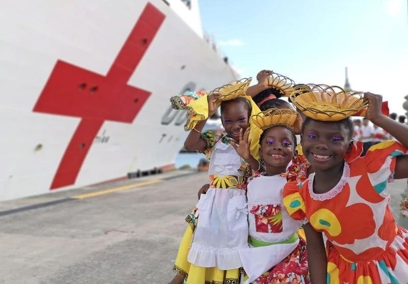 2018年10月，在安提瓜和巴布達首都圣約翰，當(dāng)?shù)匦∨笥焉泶﹤鹘y(tǒng)服裝歡迎中國海軍“和平方舟”醫(yī)院船首次到訪。