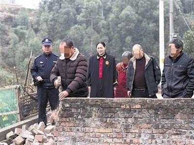  圖③：庭審結(jié)束后，在法官的見證下，陳某在院壩邊重新開鑿一條通道。