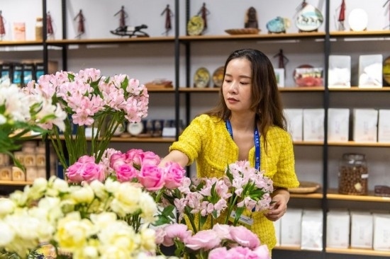 2023年7月1日，在位于湖南省長沙市的湖南高橋大市場，中非經(jīng)貿(mào)博覽會常設(shè)展館展區(qū)肯尼亞館工作人員在整理產(chǎn)自非洲的鮮花。新華社記者 陳思汗 攝