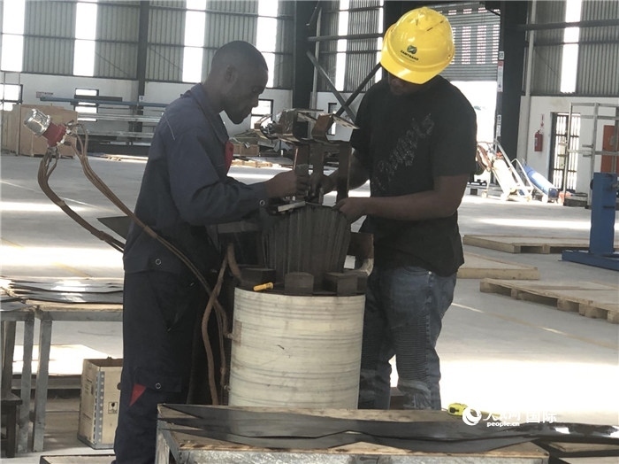 經(jīng)貿(mào)合作區(qū)廠房內(nèi)，當(dāng)?shù)毓と苏诰o張作業(yè)。人民網(wǎng)記者 黃培昭攝