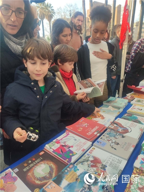 印刷精美的中國傳統(tǒng)文化叢書吸引了小游客的注意。人民網(wǎng)記者鄭彬攝