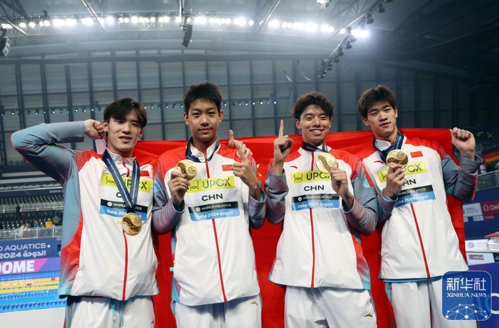 2月11日，2024年多哈游泳世錦賽男子4×100米自由泳接力決賽，中國隊(duì)選手王浩宇、張展碩、季新杰和潘展樂（從左到右）在頒獎(jiǎng)儀式后合影慶祝。新華社記者 雒圓 攝
