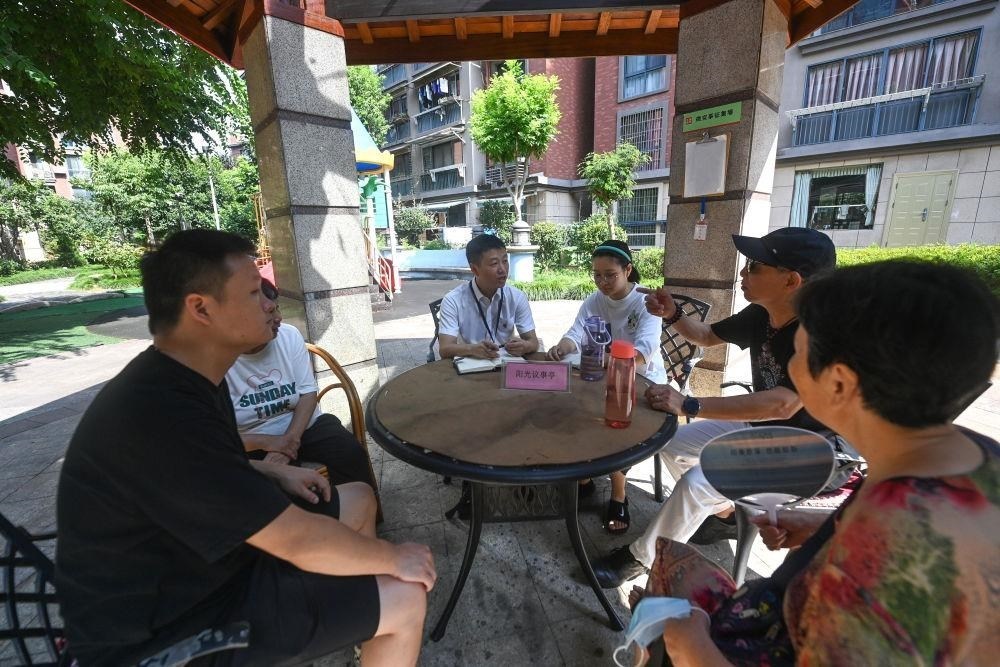 △2023年7月21日，在位于浙江杭州臨安區(qū)錦南街道水岸陽光小區(qū)的陽光議事廳，街道干部在聽取居民們反映的問題及意見。