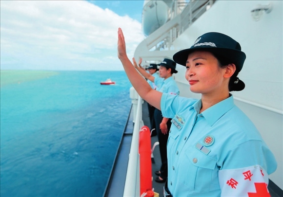 中國(guó)海軍“和平方舟”號(hào)醫(yī)院船結(jié)束訪問(wèn)湯加時(shí)，任務(wù)官兵中的文職人員向歡送人群揮手告別（2023年8月4日攝）。徐巍攝/本刊