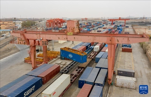 4月21日，二連浩特鐵路口岸龍門吊吊裝中歐班列集裝箱（無人機照片）。 新華社發(fā)（張海峰攝）