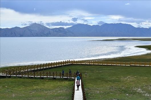 △ 游客行走在青?，敹嗫h冬格措納湖畔的木棧道上。