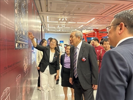 工作人員為泰國前副總理、泰中文化促進(jìn)委員會(huì)主席披尼講解展覽內(nèi)容。中國駐泰國大使館供圖