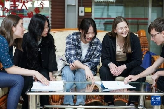 4月28日，宋智孝（右二）和胡靈月（左一）在北京首都師范大學(xué)校園內(nèi)與同學(xué)交流。新華社記者 彭子洋 攝