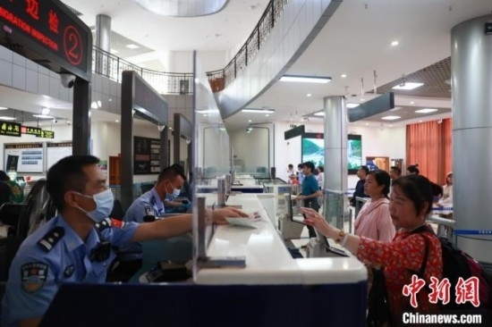 圖為旅客在磨憨口岸辦理通關(guān)手續(xù)。雷雨 攝