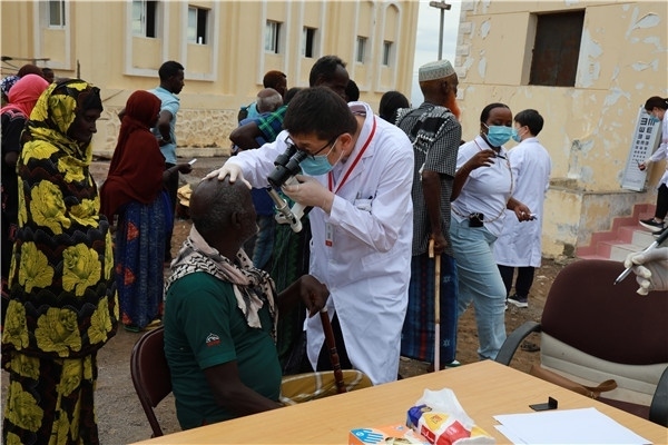 在義診現(xiàn)場(chǎng)，中國(guó)醫(yī)生與當(dāng)?shù)鼐用窈嫌傲裟?，吉布提鹽業(yè)投資公司供圖