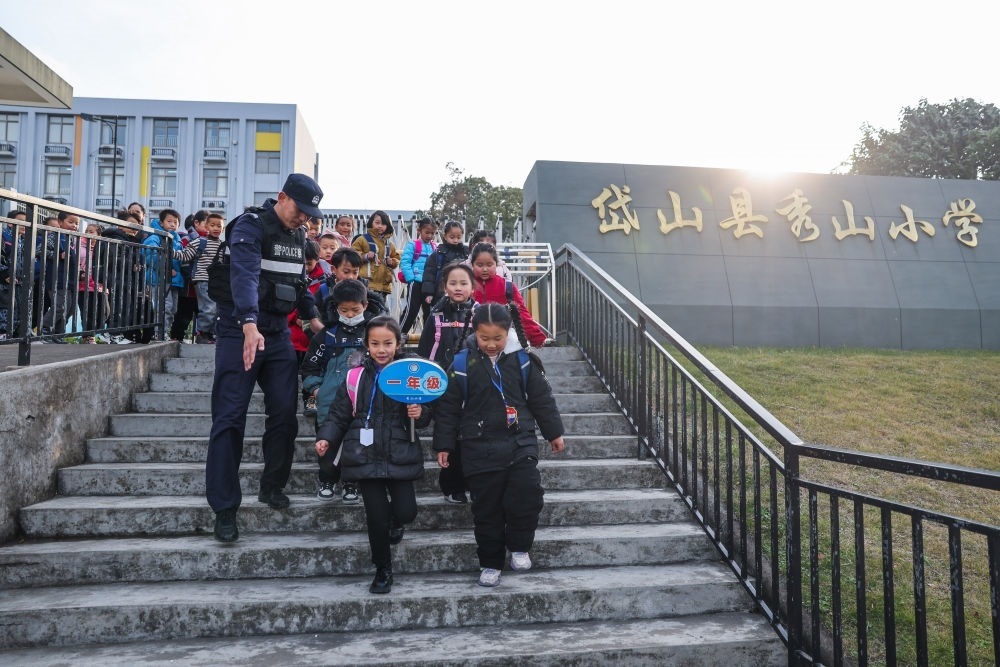 2023年12月20日，秀山派出所民警在秀山小學(xué)放學(xué)時(shí)間參與“護(hù)學(xué)崗”維持秩序，同時(shí)接獨(dú)自放學(xué)的學(xué)生去“民生小鋪”。浙江省舟山市岱山縣公安局秀山派出所聯(lián)合鄉(xiāng)鎮(zhèn)、社區(qū)成立“民生小鋪”，為當(dāng)?shù)鼐用?、外來?wù)工人員及其子女等服務(wù)，協(xié)助解決外來務(wù)工人員在工作、生活等方面的矛盾和問題，助力鄉(xiāng)鎮(zhèn)基層治理。新華社記者 徐昱 攝