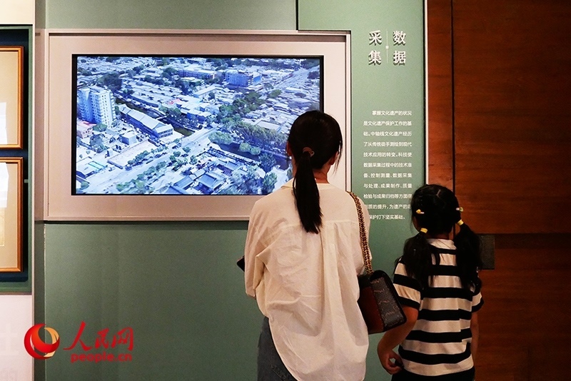 家長正在帶孩子參觀“輝煌中軸”專題展。人民網(wǎng)記者 韋衍行攝